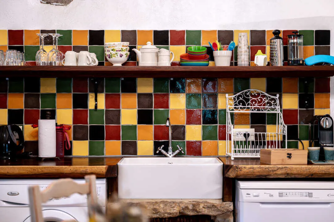Colorful tiled kitchen with sink and shelves