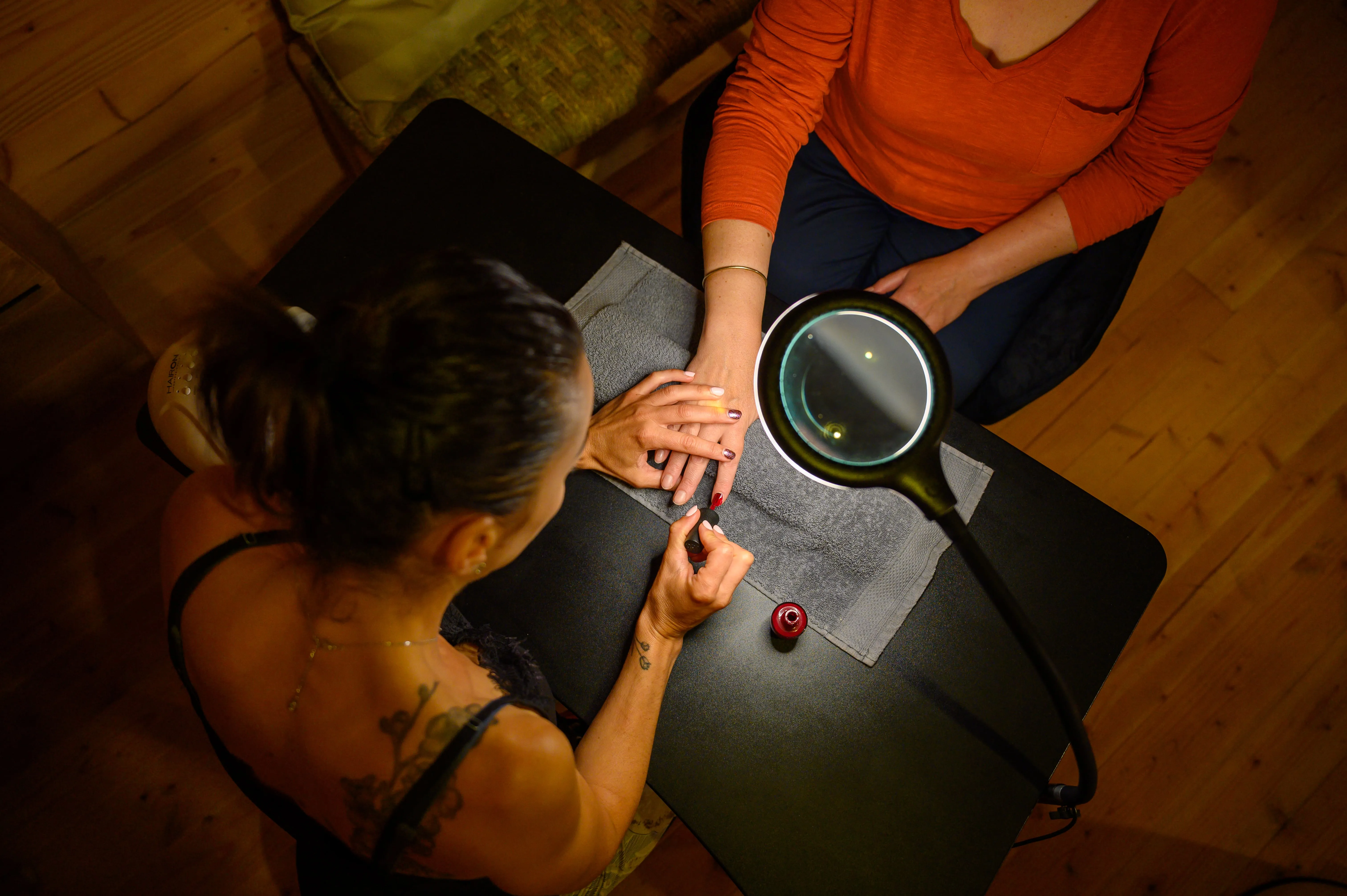 Woman receiving manicure under lamp