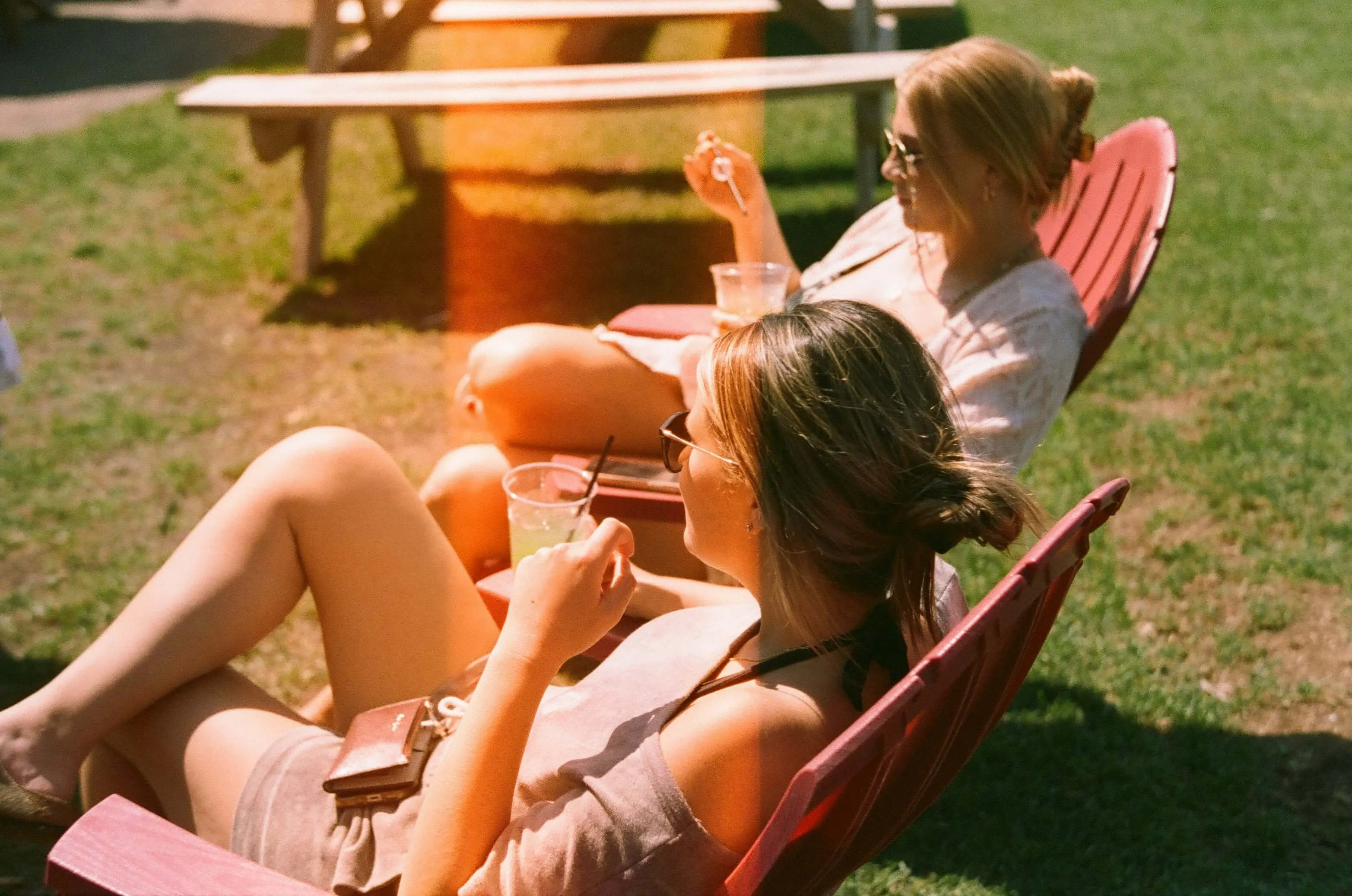 Women relaxing outdoors on Adirondack chairs